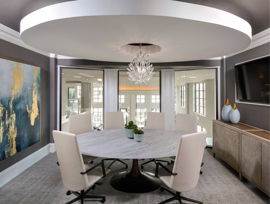 a dining room with a marble table and white chairs
