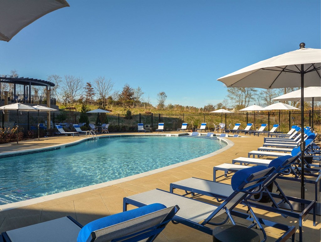 a swimming pool with lounge chairs and umbrellas at a resort