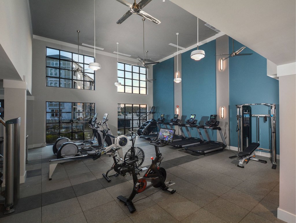 a gym with exercise equipment and windows in a building