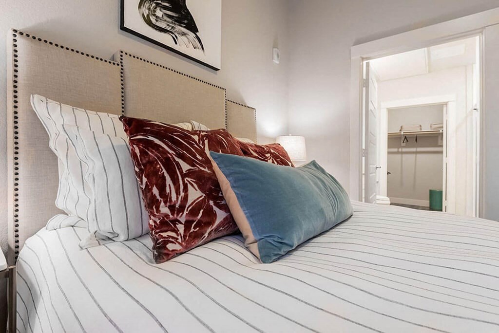 a bedroom with a large bed with pillows on it