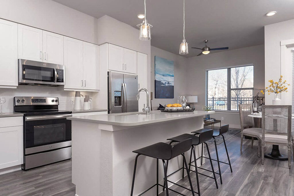 a kitchen with a large island with three bar stools