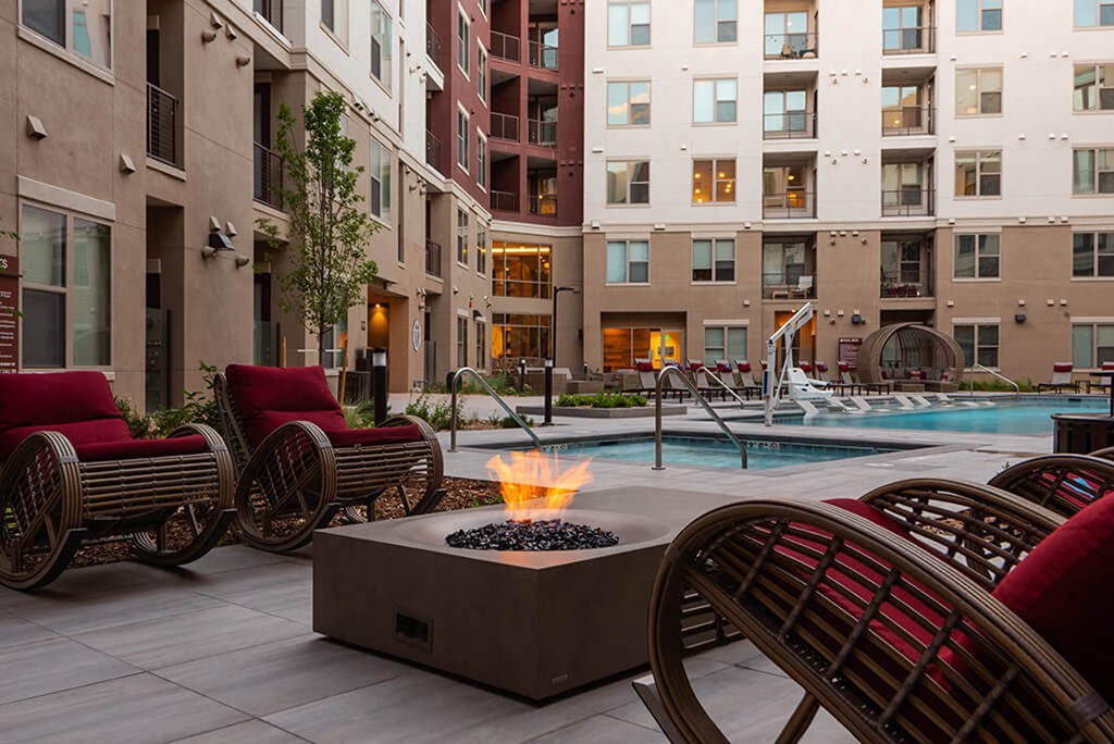 a patio with chairs and a fire pit