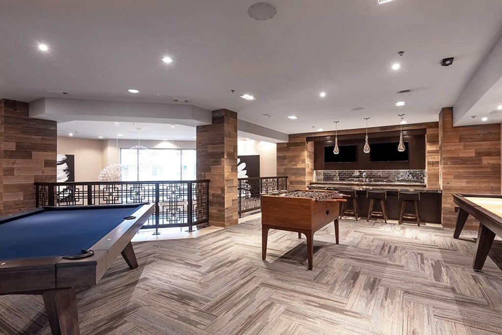 a game room with a pool table and a bar