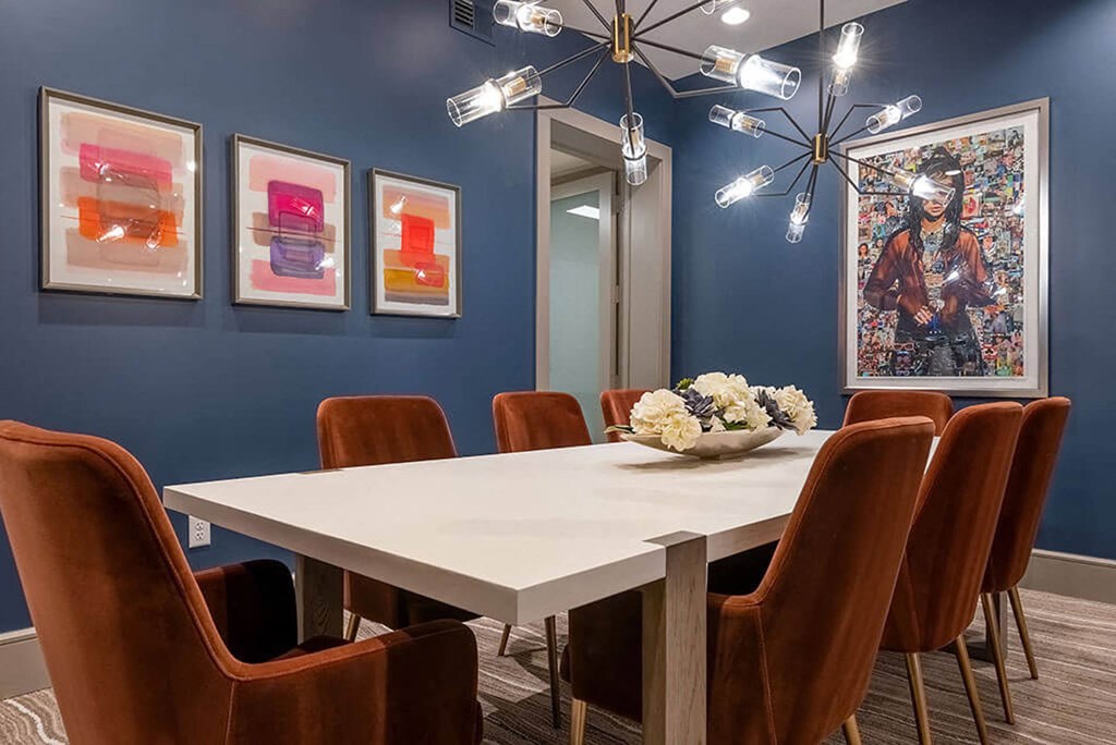 a dining room with blue walls and a white table and chairs