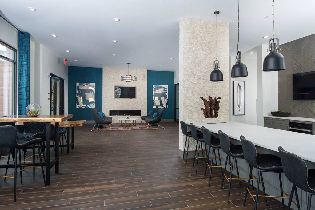 Resident lounge at Alta Clara apartments in Stoneham, MA, featuring counter seating and televisions.