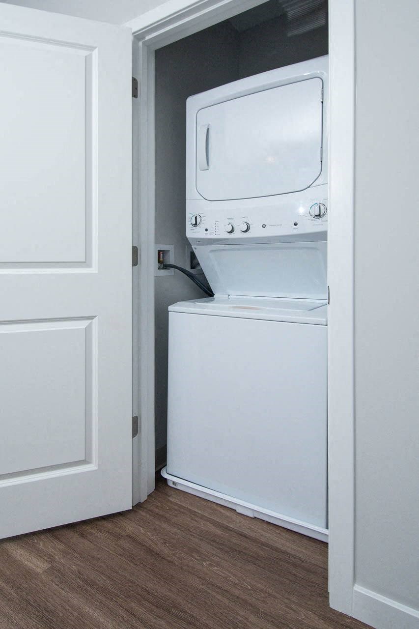 a white washer and dryer in a room with a door