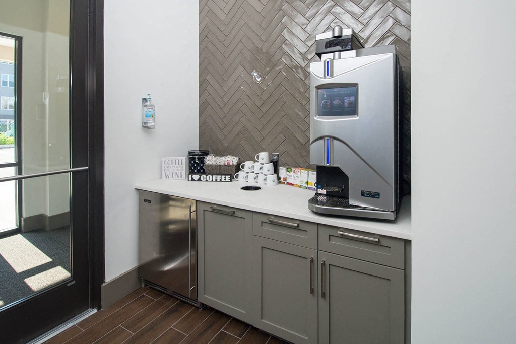 a kitchen with a coffee maker and a sink in a hotel room
