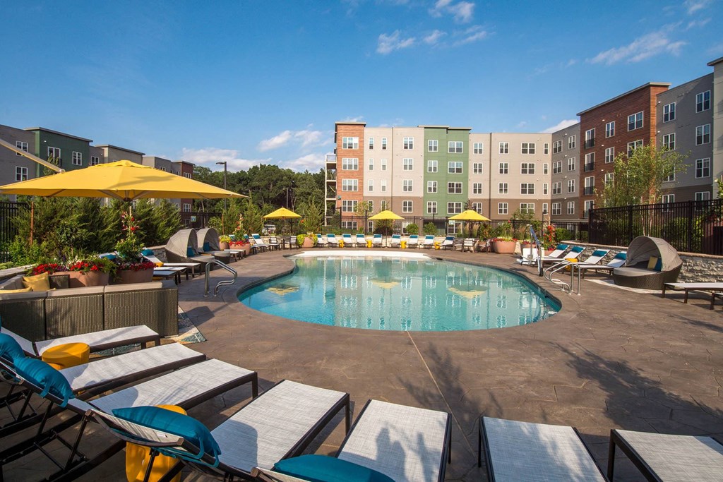 a swimming pool at a hotel with lounge chairs and umbrellas