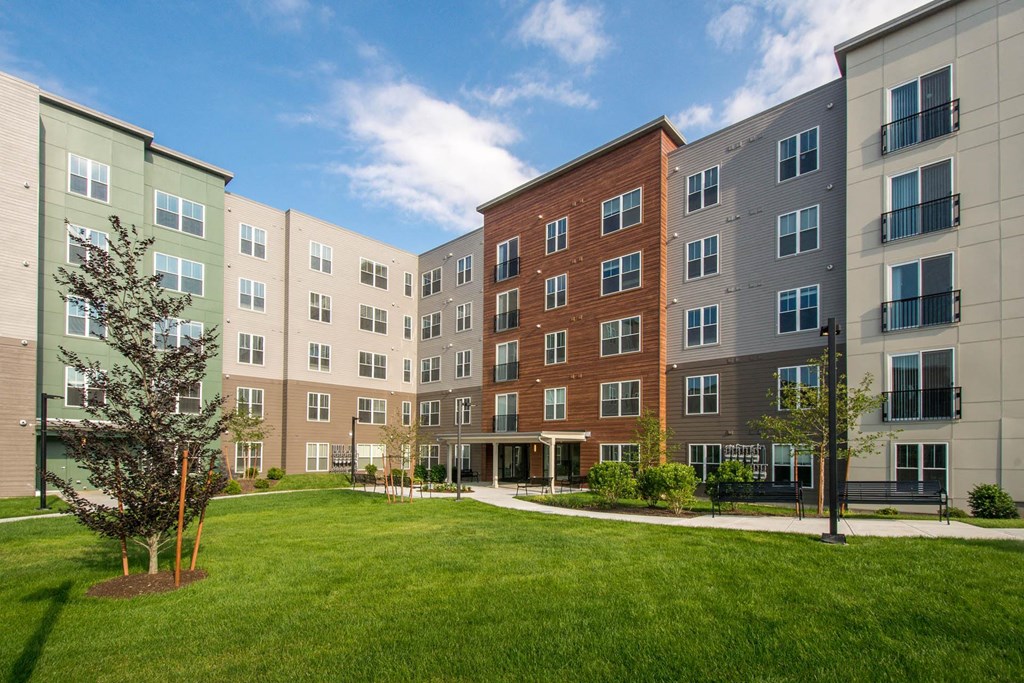 an exterior view of an apartment building with a green lawn