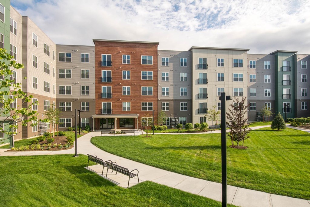 a park with a bench in front of an apartment building