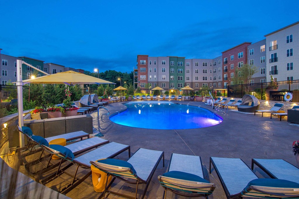 a swimming pool at night at an apartment complex