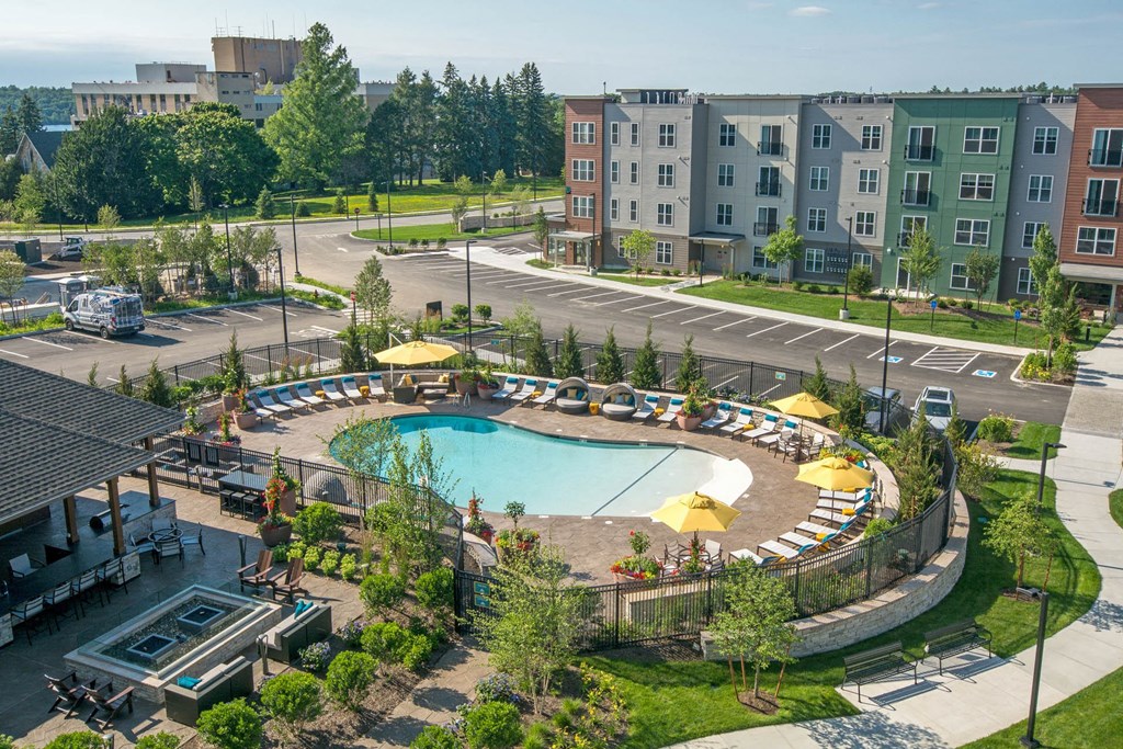 an aerial view of a swimming pool in front of an apartment building