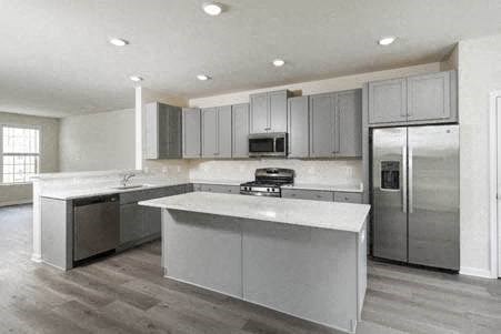 a kitchen with stainless steel appliances and white counter tops