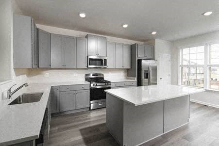 a large kitchen with a white counter top