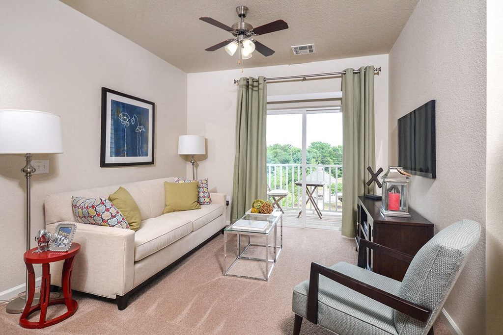 a living room with a couch and a ceiling fan