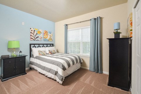 a bedroom with a bed and a large window