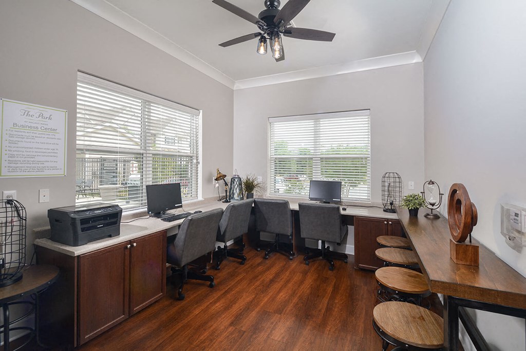 a large office with desks and chairs and a ceiling fan