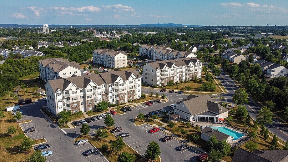 an aerial view of apartment buildings in a parking lot