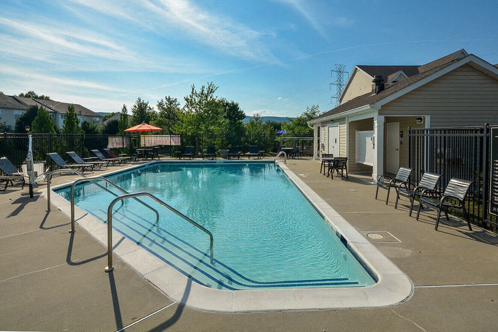 a swimming pool with chairs and a building with a house