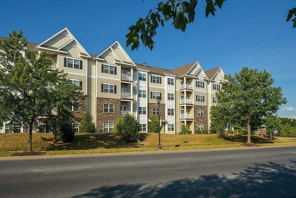 an exterior view of an apartment building on the side of a street