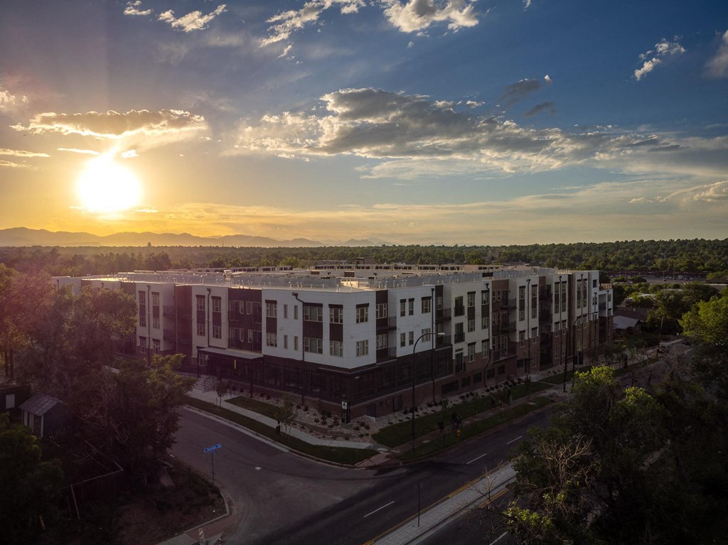 an aerial view of a building with the sun setting behind it