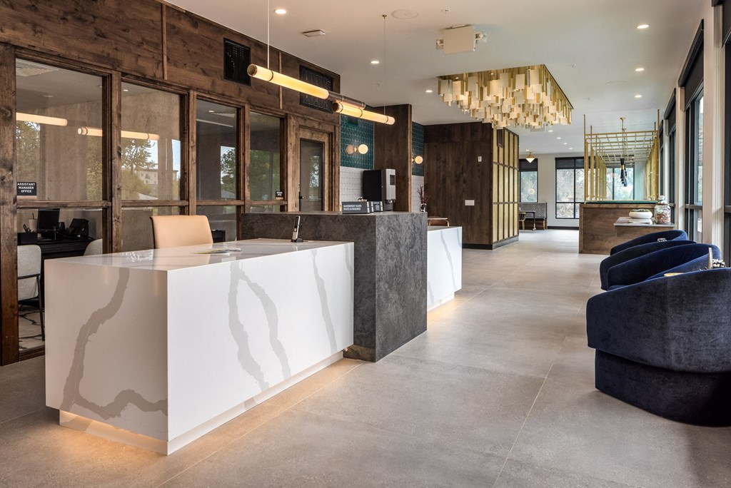 the lobby of a hotel with a reception desk and chairs