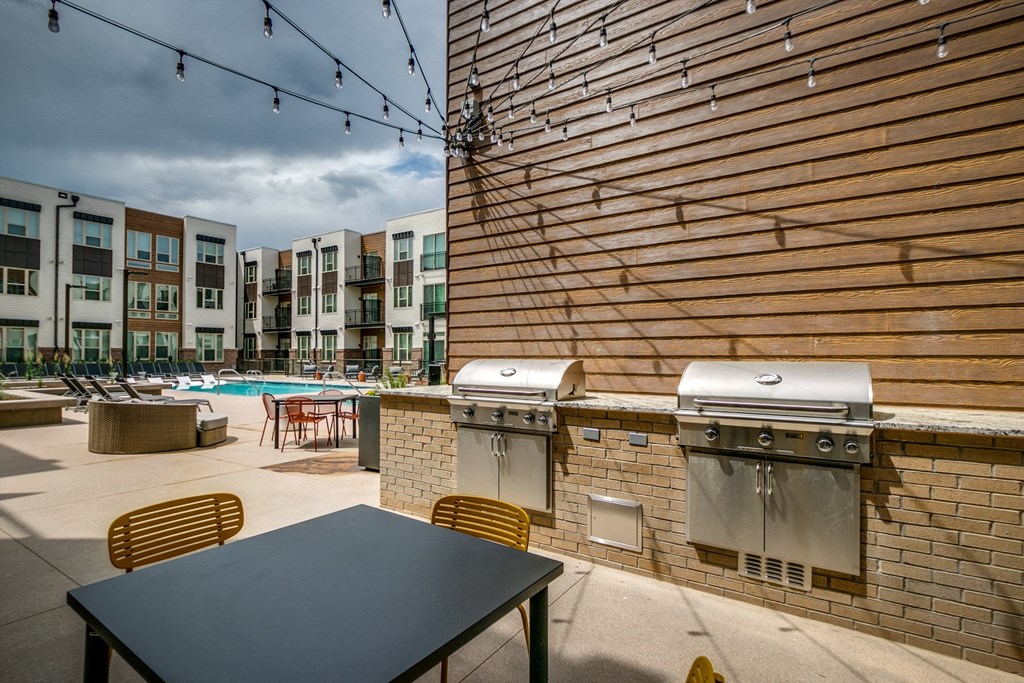 furnished patio with barbecue grills and tables at the cardinal apartments worth