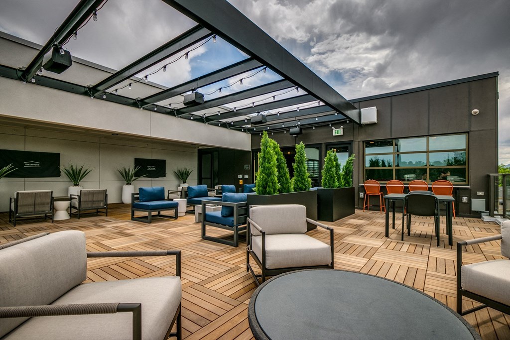 a patio with chairs and tables and a glass roof
