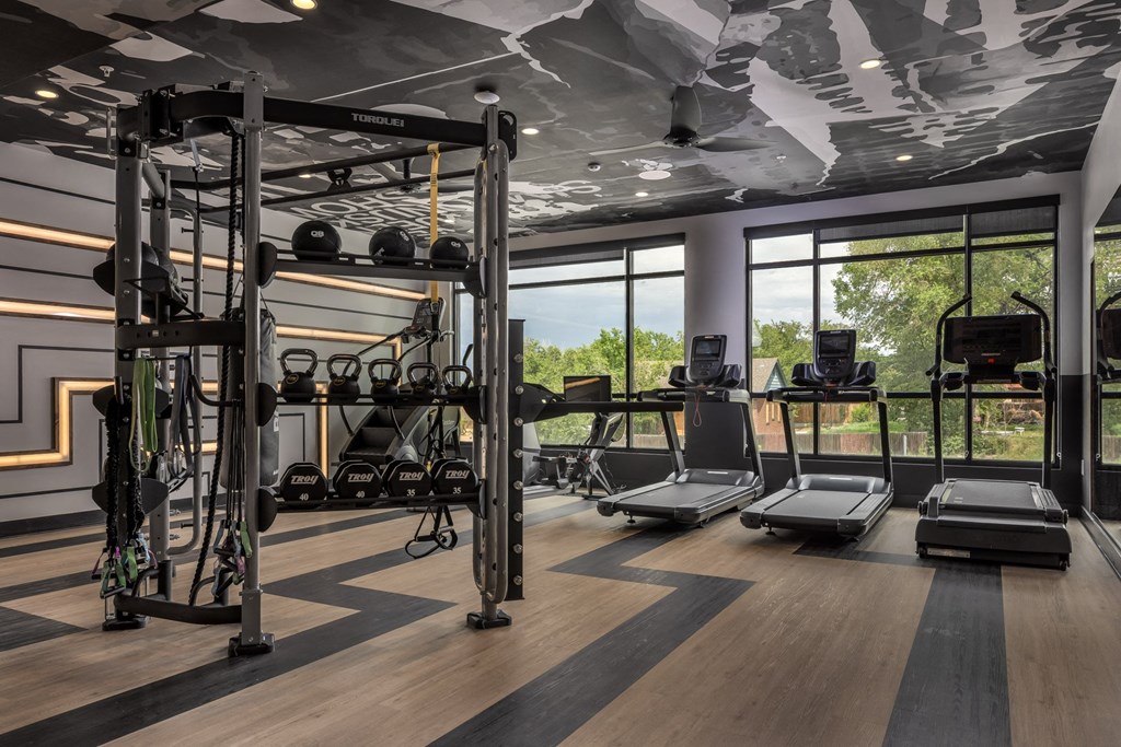 a gym with weights machines and a view of the outdoors