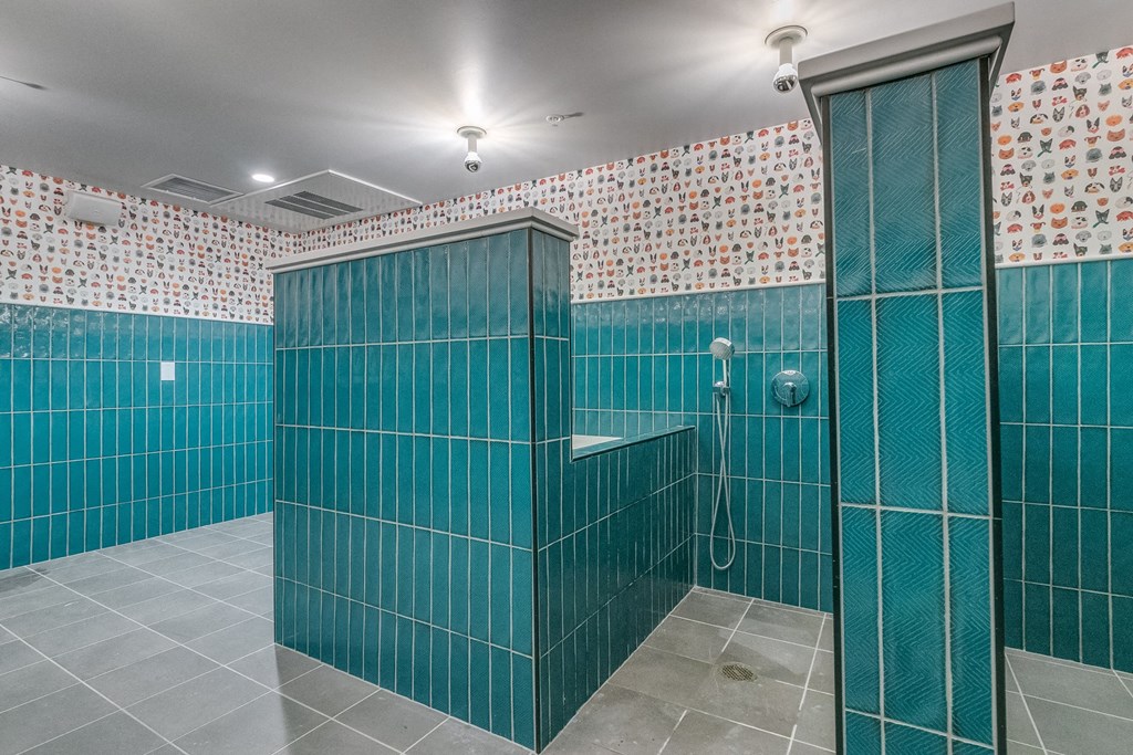 a stall in a bathroom with blue tiles