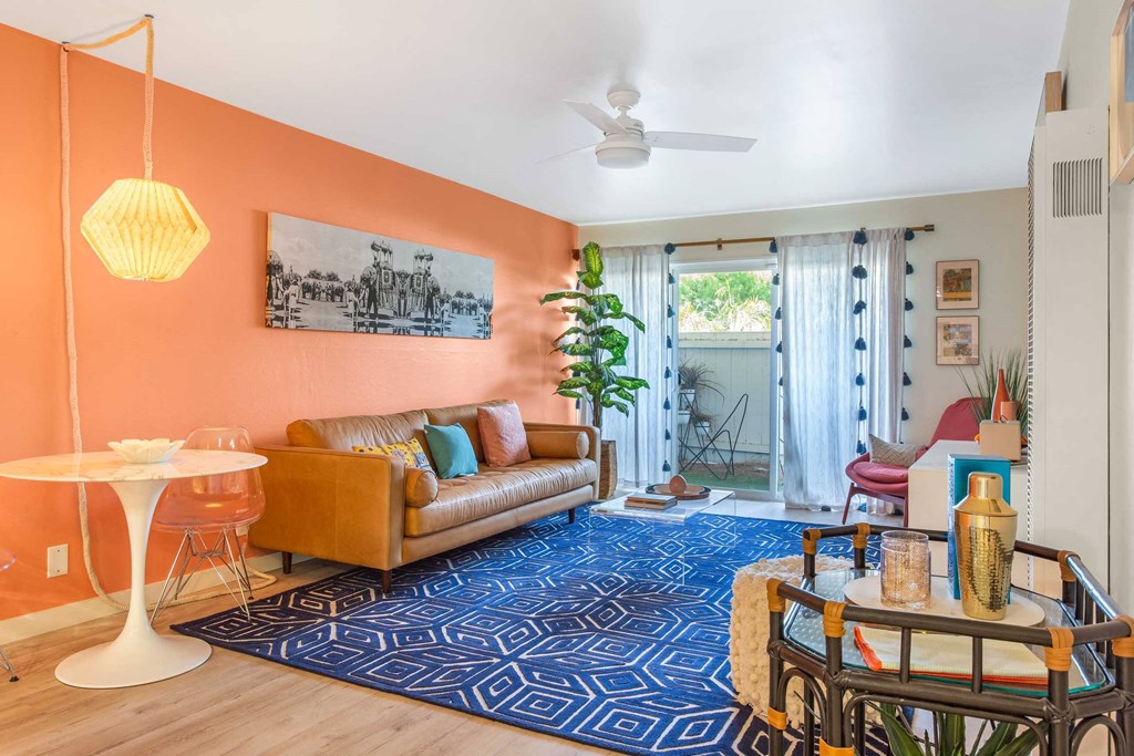 a living room with orange walls and a couch and a table