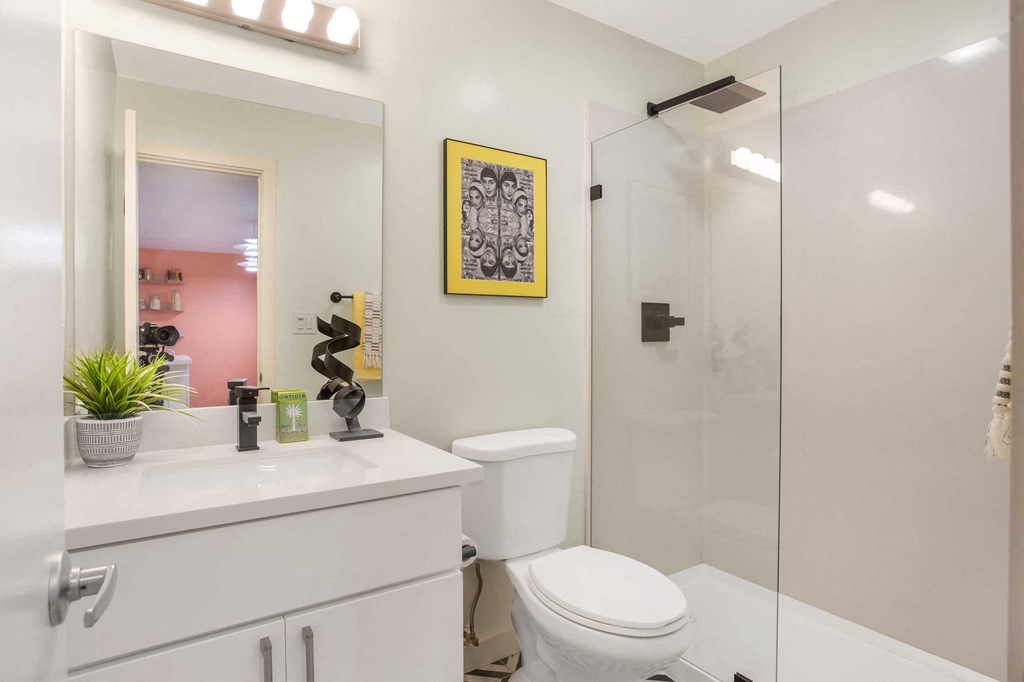 a white bathroom with a shower and a toilet