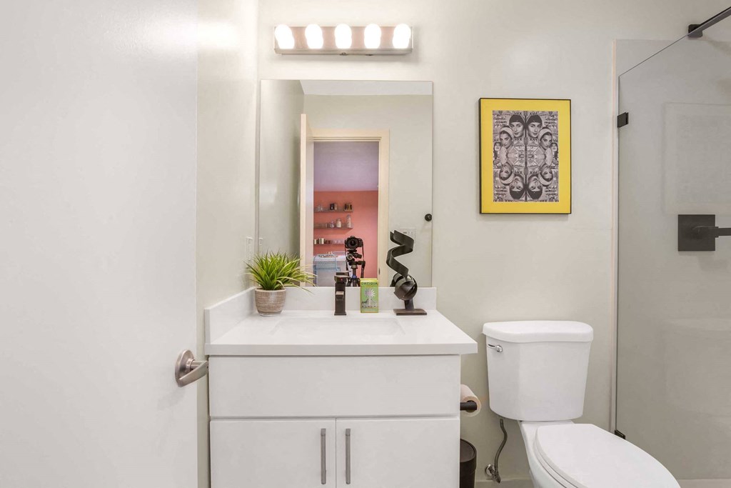 a white bathroom with a toilet and a sink