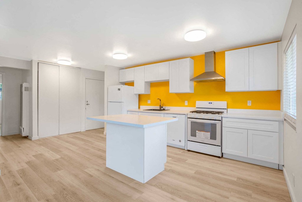 a kitchen with white cabinets and white appliances and a counter top