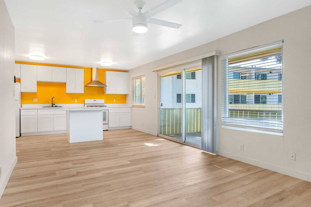 a living room with a kitchen and a sliding glass door