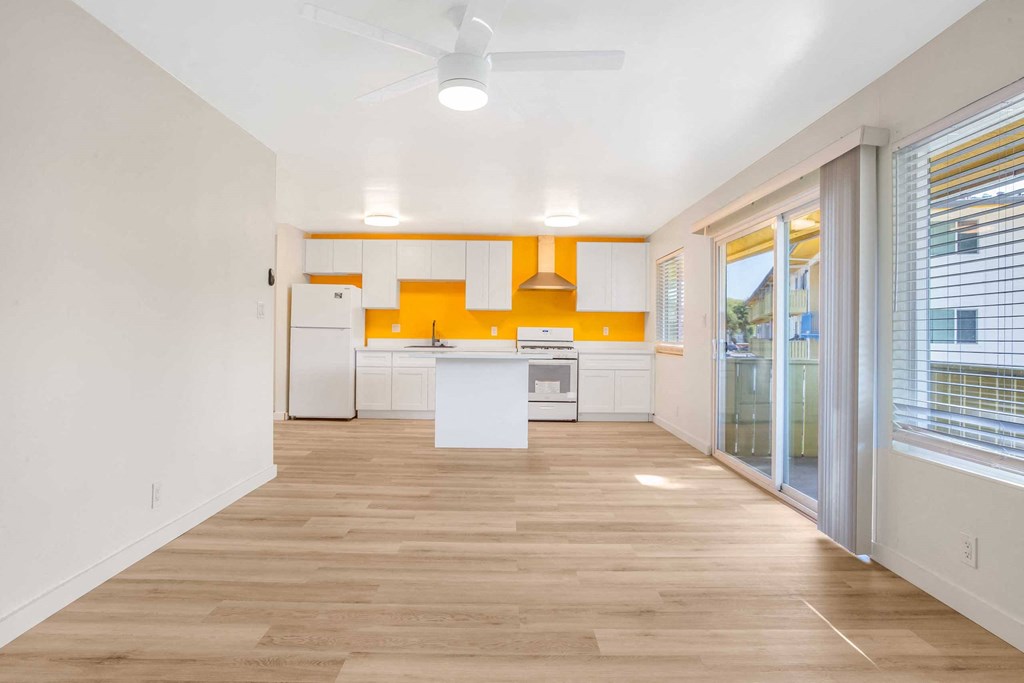 a room with a kitchen and a sliding glass door
