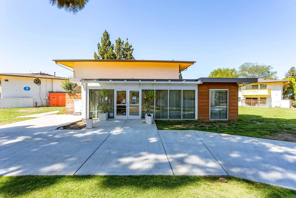 the front of a house with a concrete sidewalk and grass