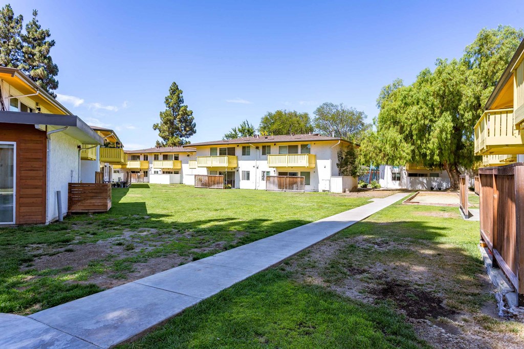 a row of houses with a sidewalk in the grass