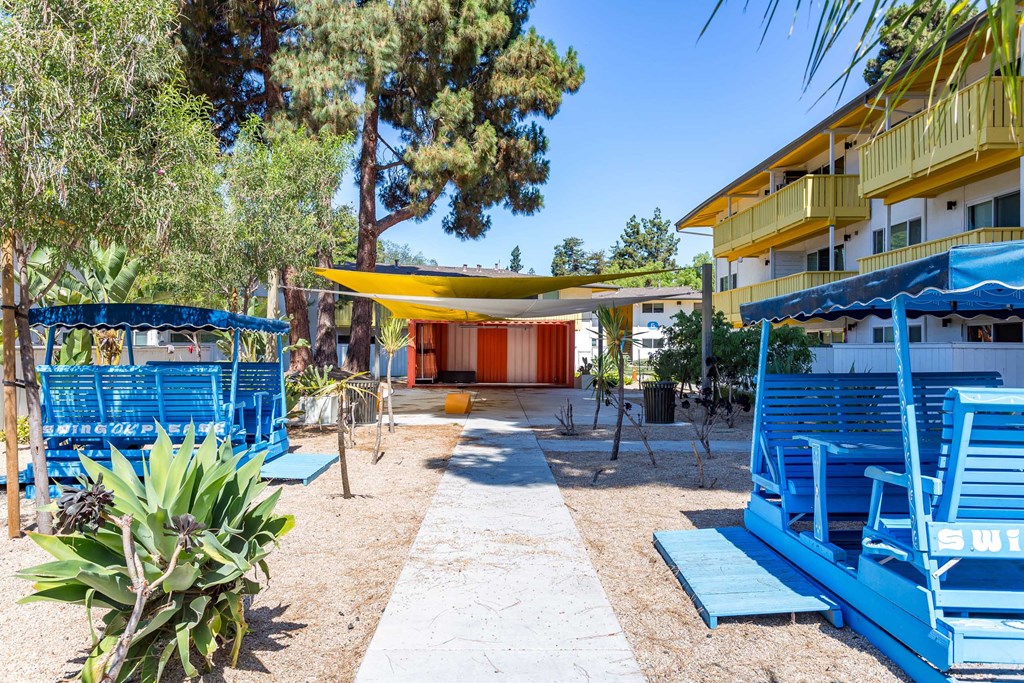 the picnic tables and umbrellas in the courtyard of a hotel