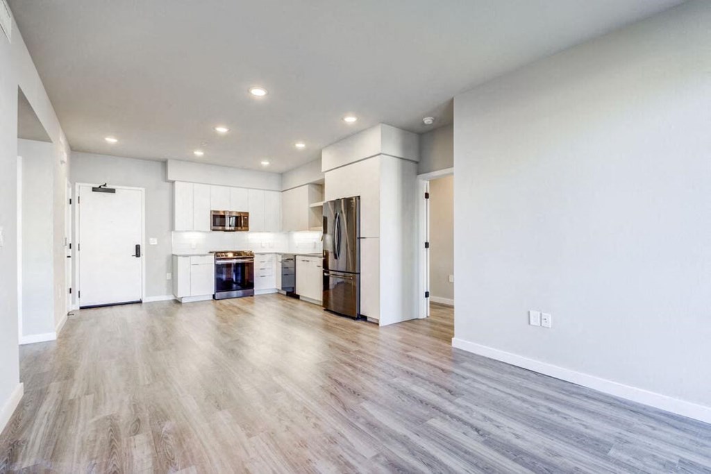 a large living room with a kitchen in the background