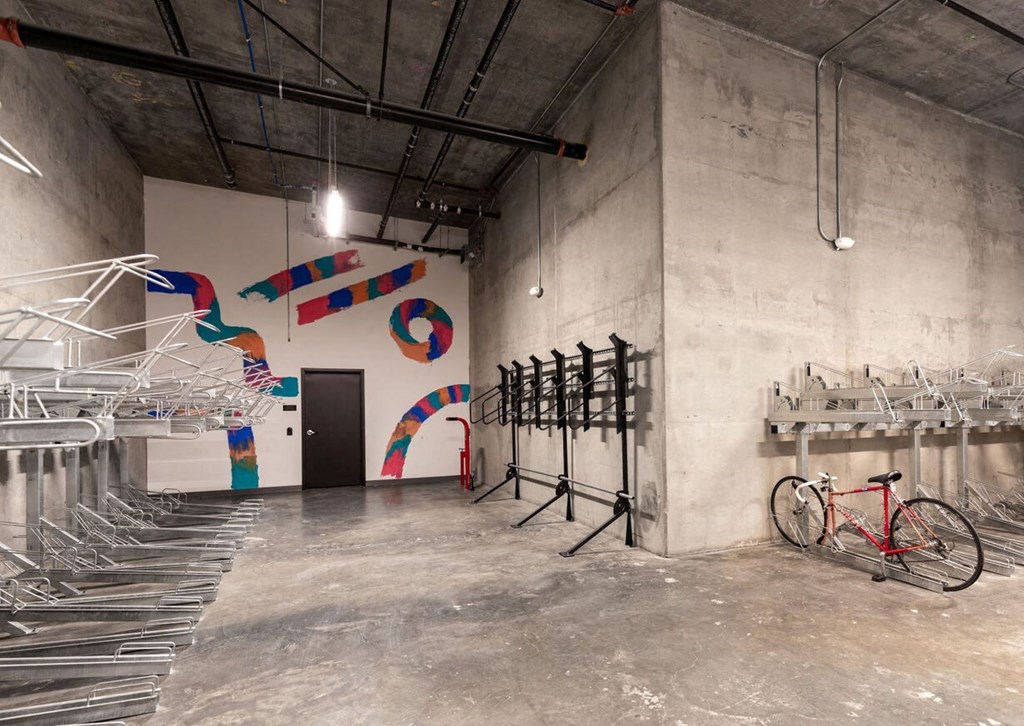 a room with a bunch of bikes and a mural on the wall