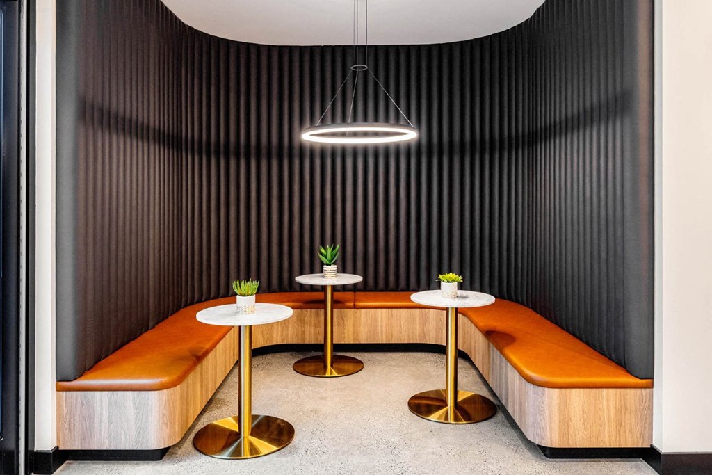 a lounge area with benches and tables and a lamp