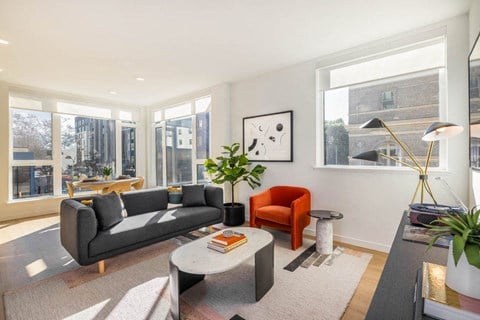 a living room with a couch and a table    and a large window