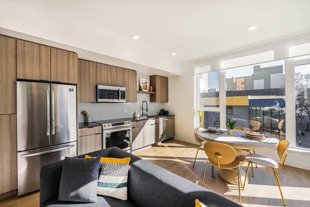 a kitchen with stainless steel appliances and a table and chairs