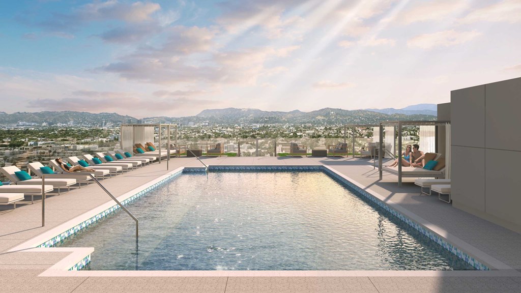 a swimming pool on the rooftop of a hotel overlooking the city