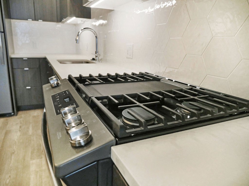 a kitchen with a stove top oven and a sink