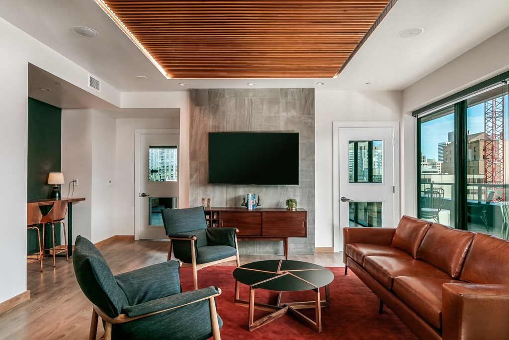 a living room with a leather couch and chairs and a television