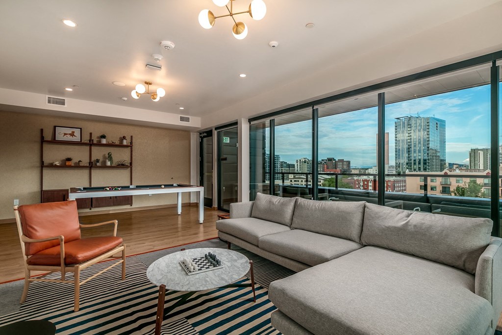 a living room with a couch and a table and a view of the city