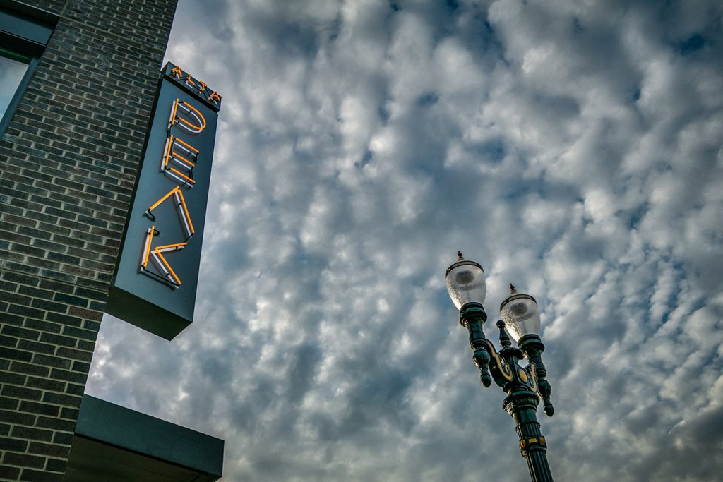 a sign on the side of a building with a cloudy sky