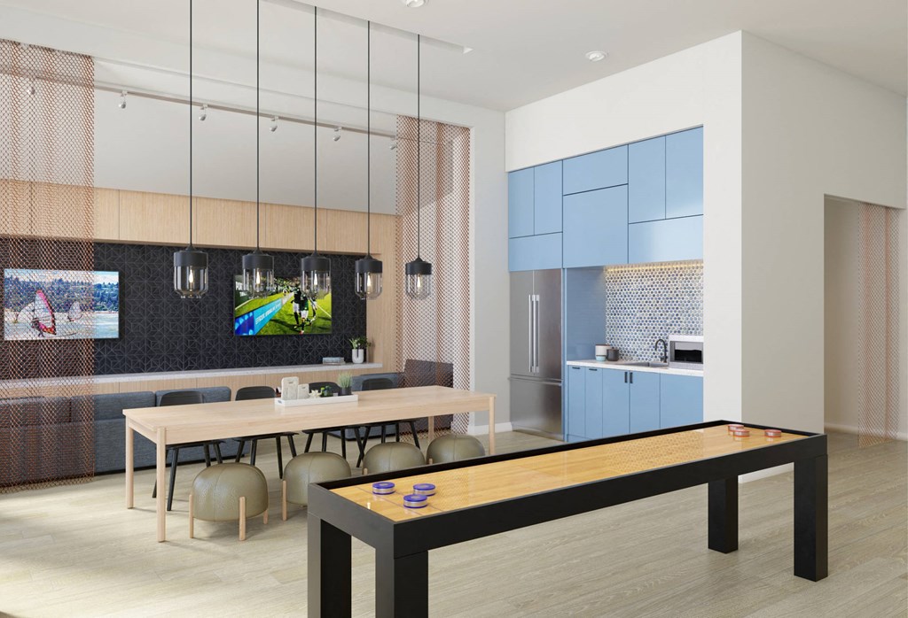 a dining room with a ping pong table and a kitchen with blue cabinets